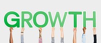 Hands holding up green letters forming the word growth