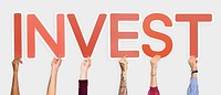 Hands holding up red letters forming the word invest