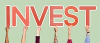 Hands holding up red letters forming the word invest