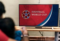 Family watching a football match on the  tv