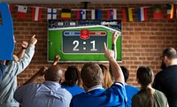 Cheerful supporters watching football at the pub