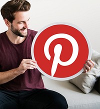 Cheerful man holding a Pinterest icon