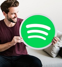 Person holding a Spotify icon