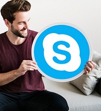 Cheerful man holding a Skype icon