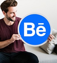 Cheerful man showing a Behance icon