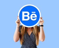 Woman holding a logo of Behance