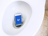 Dropbox logo showing on a phone placed in a toilet bowl. BANGKOK, THAILAND, 1 NOV 2018.