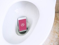 Dribbble logo showing on a phone placed in a toilet bowl. BANGKOK, THAILAND, 1 NOV 2018.