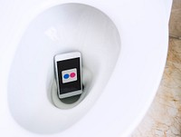 Flickr logo showing on a phone placed in a toilet bowl. BANGKOK, THAILAND, 1 NOV 2018.