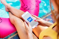 Woman using Behance application by the poolside. BANGKOK, THAILAND, 1 NOV 2018.