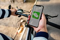 Cyclist using WeChat on a phone. BANGKOK, THAILAND, 1 NOV 2018.