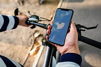 Cyclist using Twitter on a phone. BANGKOK, THAILAND, 1 NOV 2018.