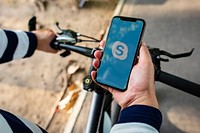 Cyclist using Skype on a phone. BANGKOK, THAILAND, 1 NOV 2018.