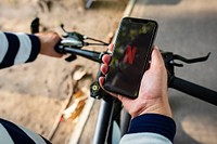Cyclist listening to Netflix on a phone. BANGKOK, THAILAND, 1 NOV 2018.