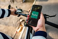 Cyclist listening to Hulu on a phone. BANGKOK, THAILAND, 1 NOV 2018.