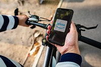 Cyclist listening to Prime Video on a phone. BANGKOK, THAILAND, 1 NOV 2018.