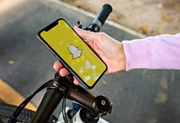 Cyclist using Snapchat on a phone. BANGKOK, THAILAND, 1 NOV 2018.