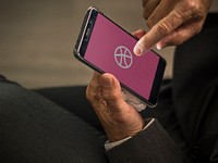 Businessman using Dribbble application on a mobile phone. BANGKOK, THAILAND, 1 NOV 2018.