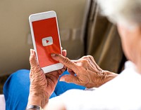Elderly woman using Youtube application on a phone. BANGKOK, THAILAND, 1 NOV 2018.