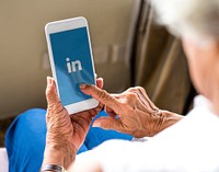 Elderly woman using LinkedIn application on a mobile phone. BANGKOK, THAILAND, 1 NOV 2018.