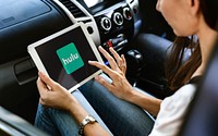 Woman watching Hulu on a digital tablet in a car. BANGKOK, THAILAND, 1 NOV 2018.