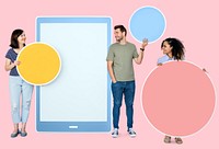 People holding geometric icons in front of a  paper cutout of a tablet