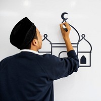 Young Muslim man drawing a mosque on a whiteboard
