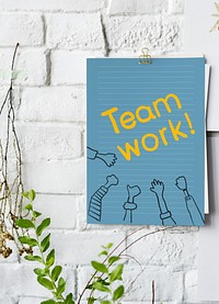 Teamwork written on a blue paper poster on white wall