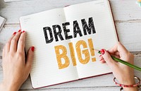 Woman writing Dream big on a notebook