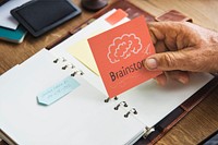 Senior hand holding a Brainstorm sticky note