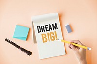 Hand writing Dream big on a notepad