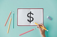 Hand drawing a dollar sign on a notebook