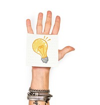 Hand showing a sticky note with a light bulb