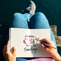 Woman drawing a piggy bank on a notebook