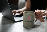 Coffee mug displayed next to a laptop