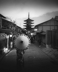 Woman in a kimono walking with an umbrella at Yasaka Pagoda in Kyoto, Japan, monotone