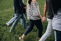 Diverse people holding hands and walking in the park, vivid tone