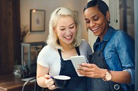 Baristas watching something funny on a phone