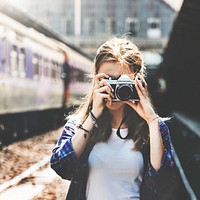 Young woman is taking photo with film camera