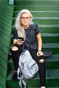 Young Woman Skater Browsing Phone Concept