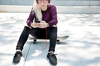 Young woman listening to music on a skateboard