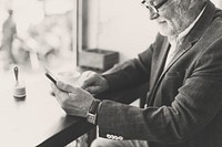 Senoir caucasian man using mobile phone in cafe