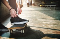 Hands tying shoes robes on skateboard