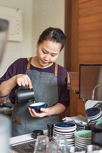 Senior woman barista preparing a cup of coffee