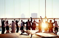 Group Of Business People With Their Arms Raised In Board Room