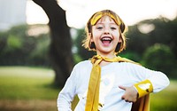 Young caucasian girl smiling wearing superhero costume in the park