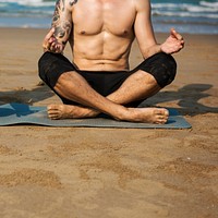 A man is doing a yoga at the beach