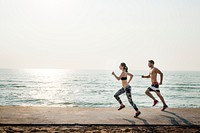 Healthy young couple running by the beach together<br />