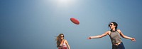 Women are playing frisbee at the beach