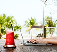 A woman is using computer laptop by the beach